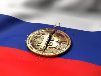 A cracked token representing Bitcoin rests on a Russian flag.